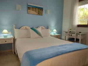 罗列特海岸皮纳莱斯旅馆的一间卧室配有一张大白色床和蓝色毯子