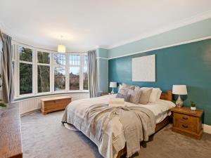 曼彻斯特Pass the Keys Large 4 Bed House with Games Room的一间卧室配有一张带蓝色墙壁的大床