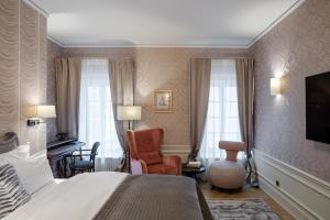 克拉科夫Hotel Unicus Palace Old Town的配有一张床和一把椅子的酒店客房