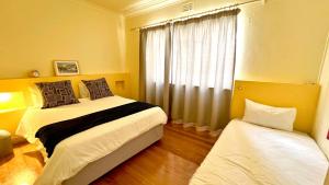 开普敦Long Street Backpackers的一间卧室设有两张床和窗户。