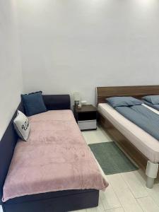 奥拉迪亚SMART GuestHouse的一间卧室设有两张床和床头柜