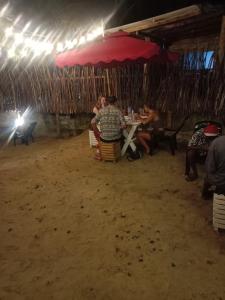 马特勒Ocean Breeze Villa的一群人坐在桌子上,在伞下