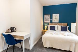 奥尔德姆Suite 5 - Stylist Spot in Oldham City Centre的一间卧室配有一张桌子、一张床、一张桌子和一张床