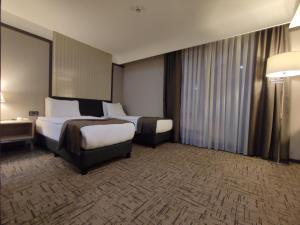 特拉布宗Invite Hotel Corner Trabzon的酒店客房设有两张床和窗户。