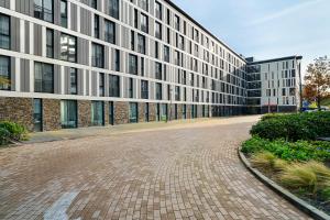 巴德胡弗多普Corendon Apartments Amsterdam Schiphol Airport的前面有砖路的大建筑