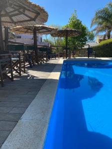 科隆卡瓦尼亚斯普马燕山林小屋的蓝色游泳池配有桌子和遮阳伞