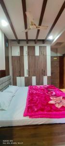 瓦拉纳西STAY DAILY INN的一间卧室配有一张带粉色毯子的大床