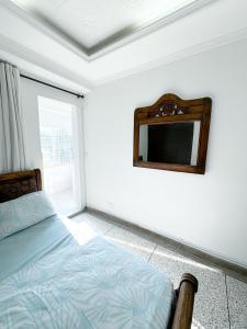 库库塔Apartaestudio Luiggis Cucuta的卧室配有一张床,墙上设有镜子