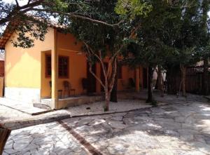 皮雷诺波利斯Recanto Rocas的前面有树木的小黄房子