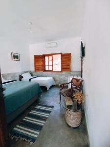 皮雷诺波利斯Recanto Rocas的一间卧室设有两张床、一张沙发和一个窗口