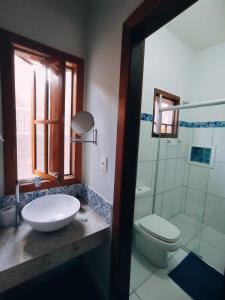 皮雷诺波利斯Recanto Rocas的一间带水槽和卫生间的浴室以及窗户。