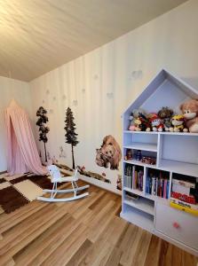 波罗宁HAFCIK Apartamenty przyjazne dzieciom的儿童间,设有书架和椅子