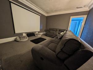 BonnybridgeBonnyside House的客厅设有大沙发和大屏幕电视