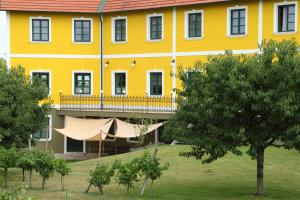 贡特拉姆斯多夫贡特拉姆斯多夫怀旧汽车旅馆的一座大型黄色建筑,设有阳台和树木