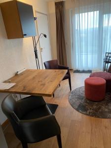 辛佩尔费尔德Hotelkamer Bellevue的客厅配有桌子和椅子