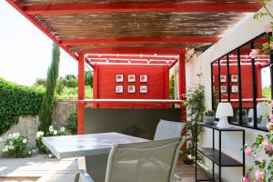 奥朗日L’annexe的一个带桌椅的庭院和一座红色建筑