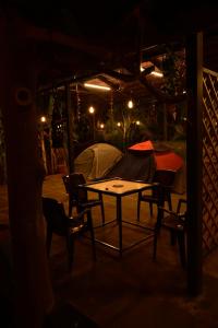 丹德利Dandeli Resorts Booking的晚上在庭院里摆放着桌椅