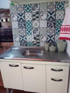 隆德里纳Simples e confortável的厨房设有水槽和瓷砖墙