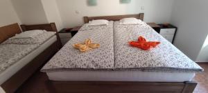 伏尔塔瓦河畔赫卢博卡Apartmán Hluboká nad Vltavou的卧室内的两张床,上面有橙色的弓