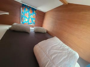 杜柏Bungalow Belle Vue en Tiny-house - Camping International - Bomal - Durbuy的一间卧室设有一张大床和一个窗户。