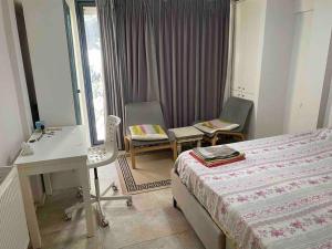 伊斯坦布尔Balat’ta huzurlu bir konaklama的卧室配有一张床、一张桌子和椅子