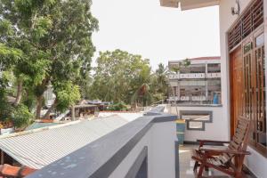 阿鲁甘湾Chimaca Bay Hotel的阳台享有带长凳的建筑的景致。