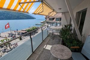 布鲁嫩Lake Lucerne Paradise apartment的阳台配有桌子,享有海滩美景