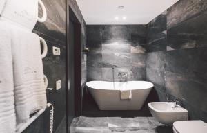 克莱佩达Dunetton - self check-in hotel的带浴缸、卫生间和盥洗盆的浴室