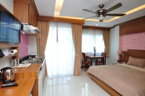 芭东海滩绿色海港酒店 & 服务公寓的一间卧室配有一张床,厨房配有水槽