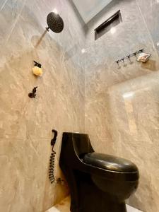 岩望seVilla Guest House Pasuruan的一间带黑色卫生间和淋浴的浴室