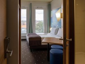 富尔达B&B Hotel Fulda-City的酒店客房设有床和窗户。