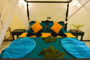 希克杜沃Monkey Island Hotel的一间卧室配有一张带蓝色床单和黄色枕头的床。