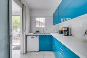 勒布斯卡Jolie maison au Bouscat avec jardin的蓝色和白色的厨房,配有蓝色的橱柜