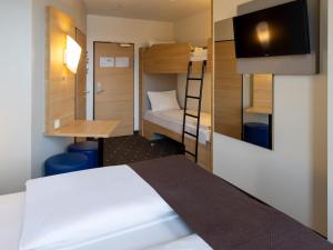 富尔达B&B Hotel Fulda-City的小房间设有一张床和一张双层床