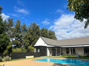 弗朗斯胡克Lynx Wine Estate的一座房子前面设有游泳池