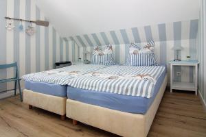 ZirchowSemi-detached house Dock No- 7-0 Zirchow - DOS081jai-L的一间卧室配有一张蓝色和白色条纹的大床