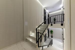 乌日霍罗德Luxury Apartments Laborca的白色墙壁和黑色栏杆的房子里的楼梯