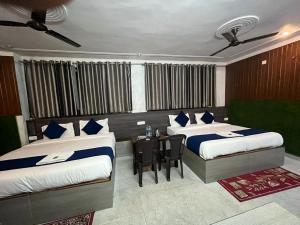 瑞诗凯诗Namastexplorer Rishikesh的一间设有两张床和一张桌子的房间