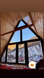 KurmentyKolsay Village的配有木制天花板的客房内的大窗户
