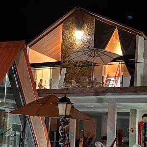 蒂安瓜Villa Suíça, Chalé Mezanino的房屋设有带遮阳伞的庭院