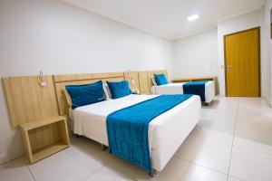 卡达斯诺瓦斯HOT SPRINGS HOTEL - BVTUR的一间卧室配有两张带蓝色枕头的床