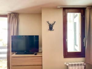 BreuilAlpine Studio with Garage的客厅配有电视,墙上挂着鹿头