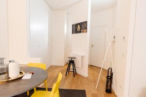 布雷西亚Open space nel pieno centro di Brescia的一间带桌子和黄色椅子的用餐室