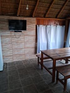 德尔迪阿布罗角Cabaña frente al mar的客房设有木桌、电视和桌子。