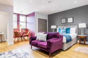 伯恩茅斯Tower House Apartments的一间卧室配有一张床和一张紫色沙发