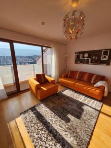 班斯科One Bedroom Apartment Pirin Lodge的客厅配有橙色家具和大窗户