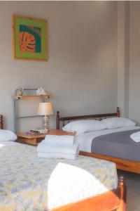 萨利纳斯Hostel Casa Betancourt的一间卧室配有两张床和一张带台灯的桌子