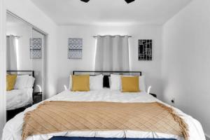 迈阿密花园Serene Poolside Getaway的白色卧室配有一张带黄色枕头的大床