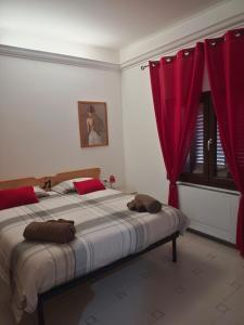 IlbonoLe Sorgenti Guest House的一间卧室配有一张带红色窗帘的大床