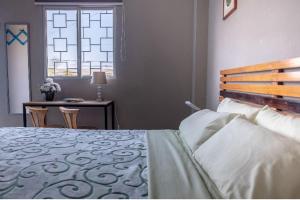 萨利纳斯Hostel Casa Betancourt的一间卧室配有一张床、一张书桌和一个窗户。